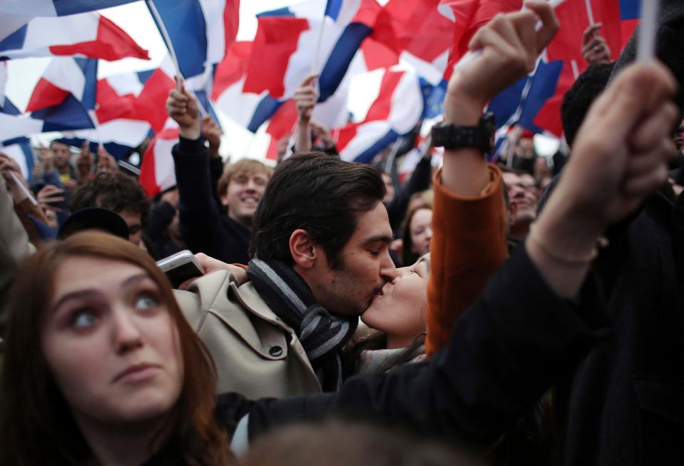 Macron supporters share a kiss in the jubilant crowds which gathered outside the Louvre Museum in Paris