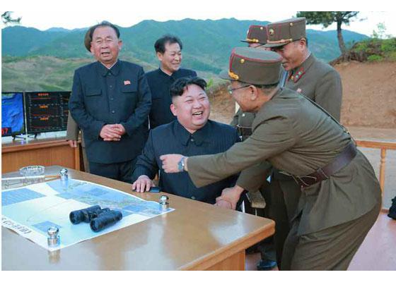  One of the despot's close aides appears to hug a jubilant Jong-un following Sunday's successful rocket blast