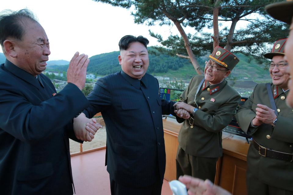 Kim celebrates with his officers after the successful launch on the weekend