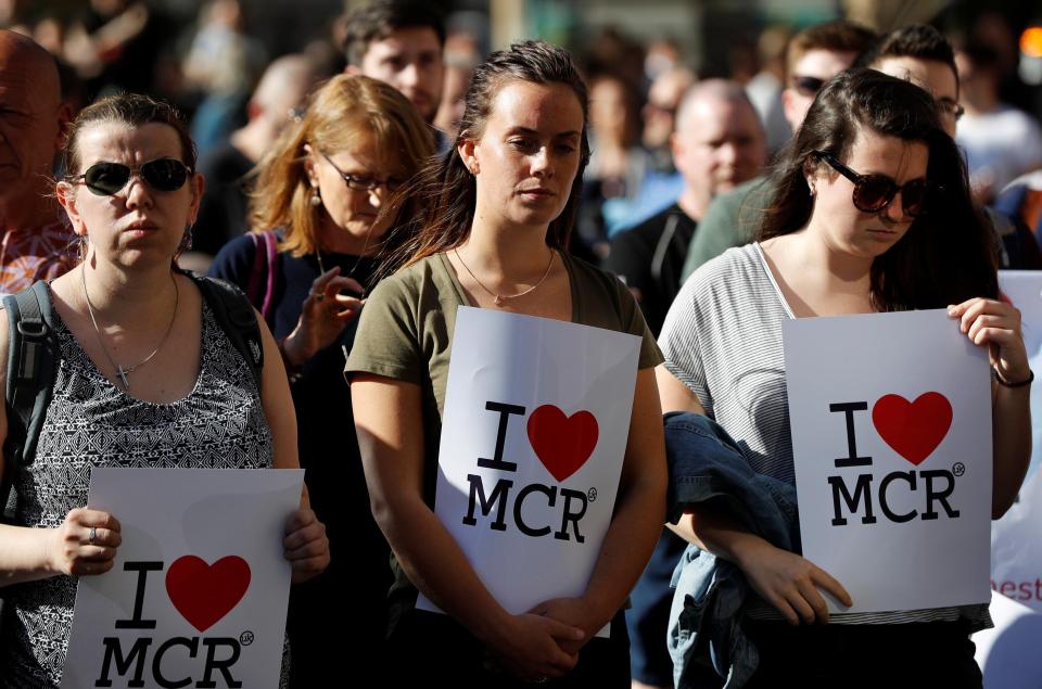  Three women stand solemnly at the vigil in Albert Square