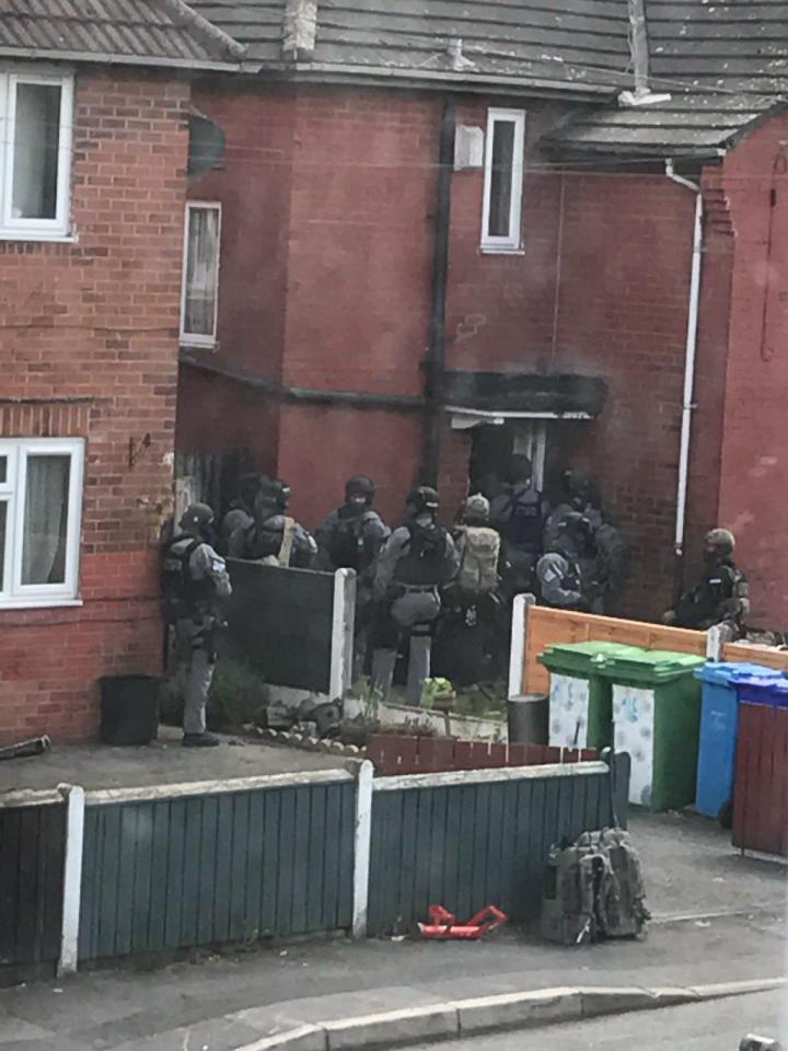  Armed police pictured preparing to storm into the bombers Manchester home yesterday