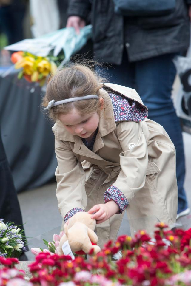 A little girl in Galsgow lays a toy dog to show her respects