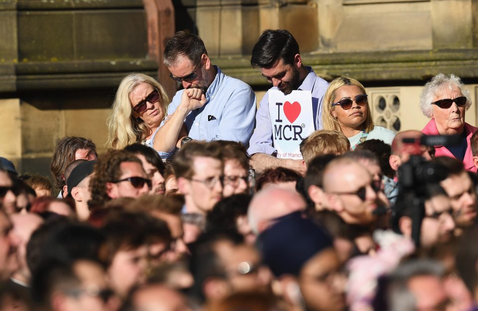 Members of the public bow their heads during tributes to the dead