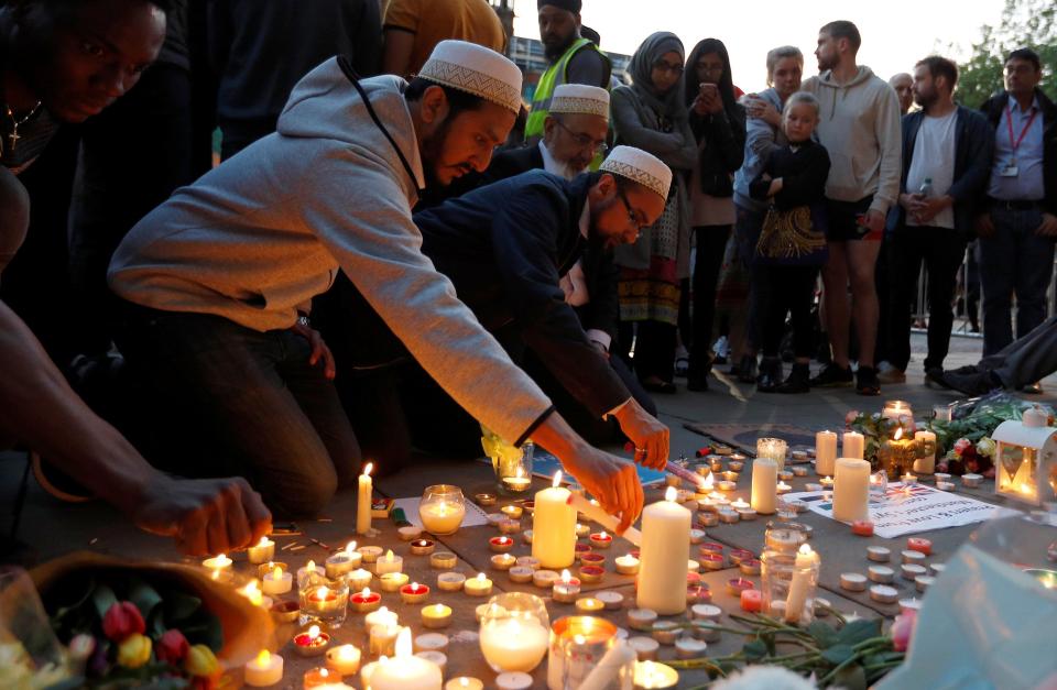Muslim men in Manchester light candles to honour the dead