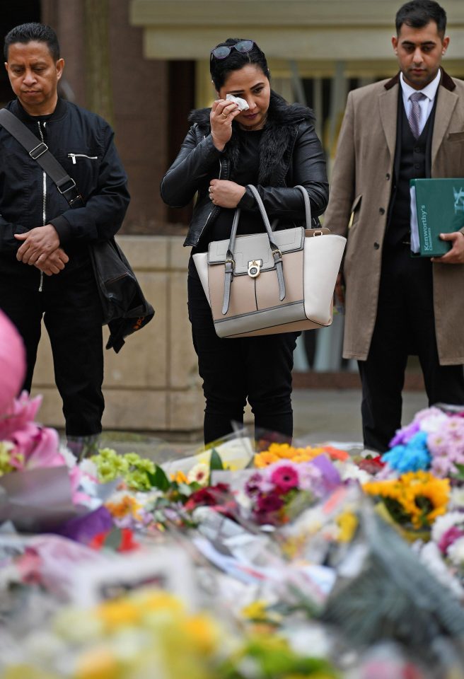  Members of the public pause to look at floral tributes and messages in St Anns Square, Manchester