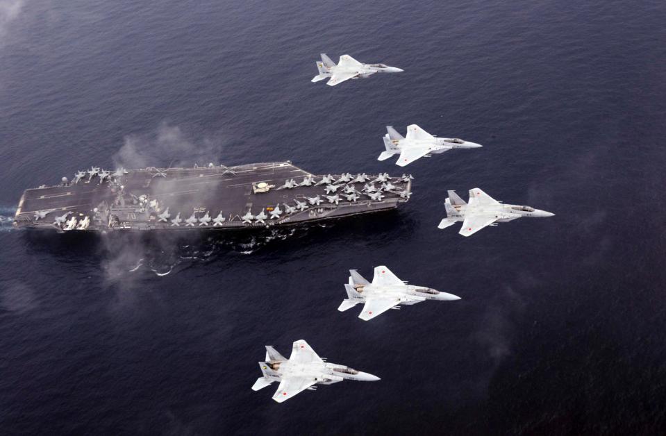Japan Air Self-Defense Force's F-15 fighter jets fly over U.S. Navy aircraft carrier USS Carl Vinson 
