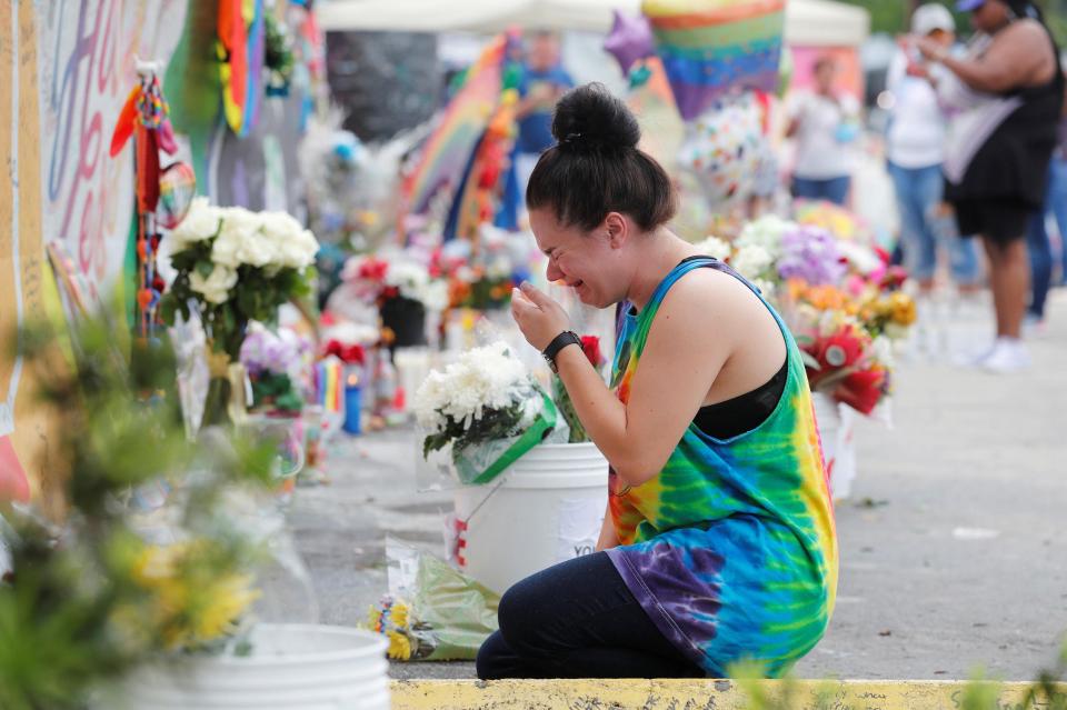 A mourner breaks down in tears in front of a floral tribute to those killed in the nightclub massacre