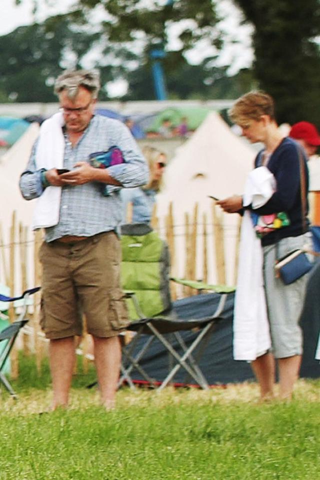 Ed Balls and Yvette Cooper were seen checking their phones in the Glastonbury shower queue
