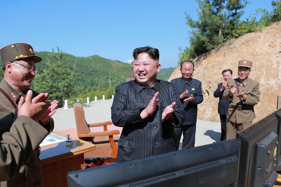  Kim Jong Un reacts with scientists and technicians after the test-launch