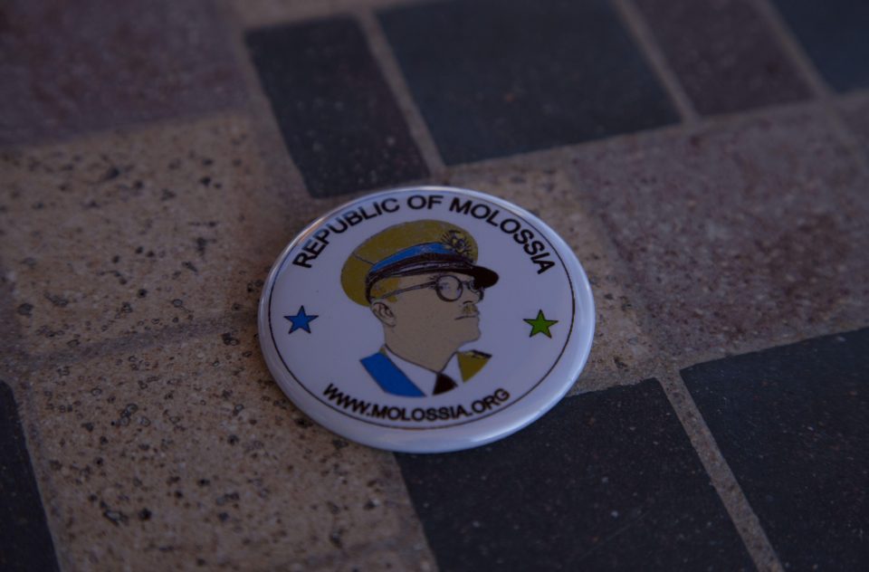 A badge bearing the glorious profile of Molossias leader and founding father