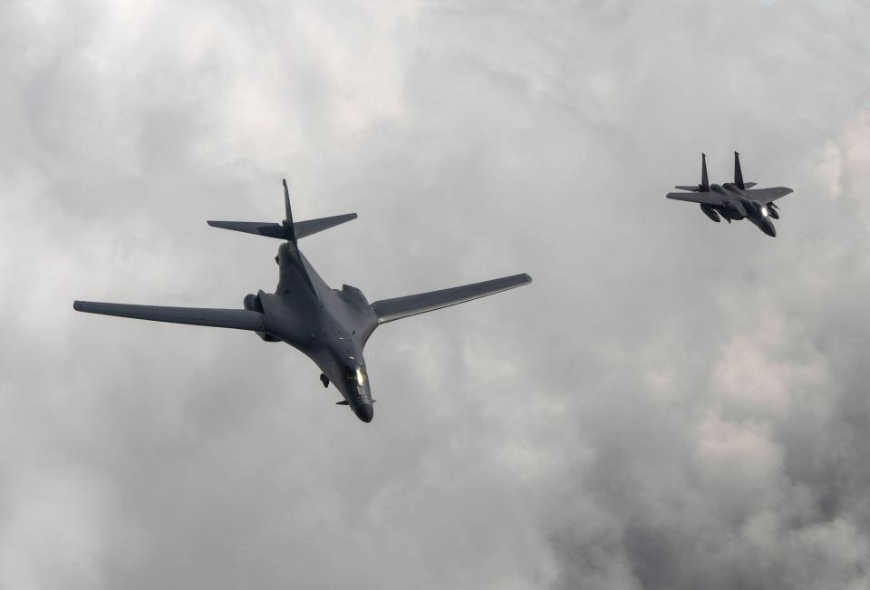  A US Air Force B-1B bomber, left, flies with a South Korean fighter jet F-15K over the Korean Peninsula on Sunday