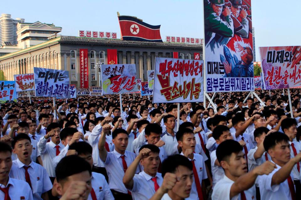Party supporters carried signs like the one second from right, which reads, 'American imperialists, dare not run wild!'