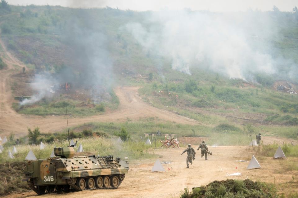  Chinese soldiers deploy with anti-tank weapons from a WZ531 armoured personal carrier