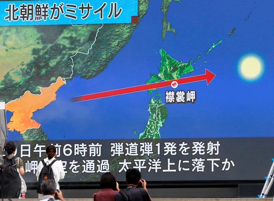 People in Japan woke to news reports of the launch as residents in Tokyo walk by a screen showing the launch