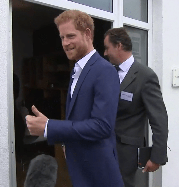 Prince Harry gives a thumbs up as he is asked about the royal baby news