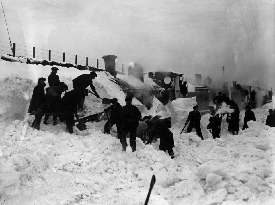  A train snow plough being dug out of deep snow in Amesbury, Wiltshire