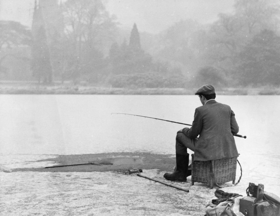  A man fishing by the side of a lake in Notts on New Year's Day, after cutting through six inches of ice to do so