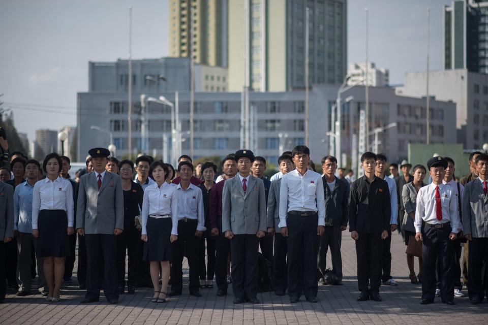 Spectators gather to watch North Korean leader Kim Jong-Un's statement outside the central railway station in Pyongyang