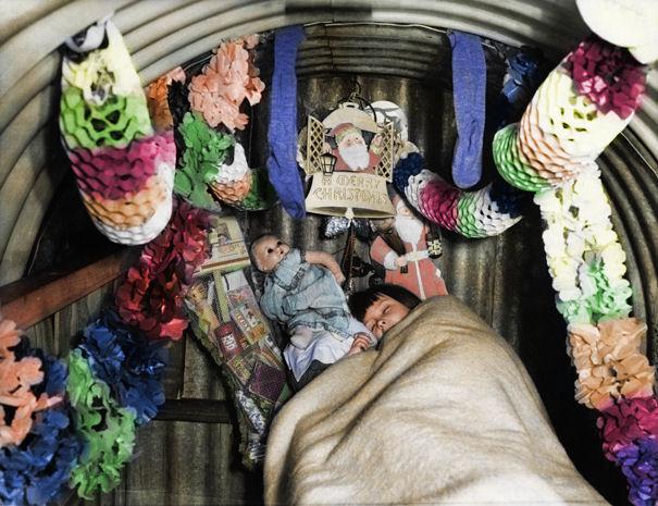  A child sleeping in an air raid shelter, decorated for Christmas