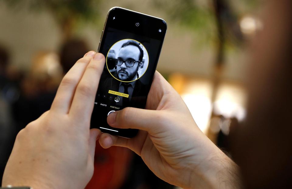 A customer checks out the new face recognition software on the new iPhone X