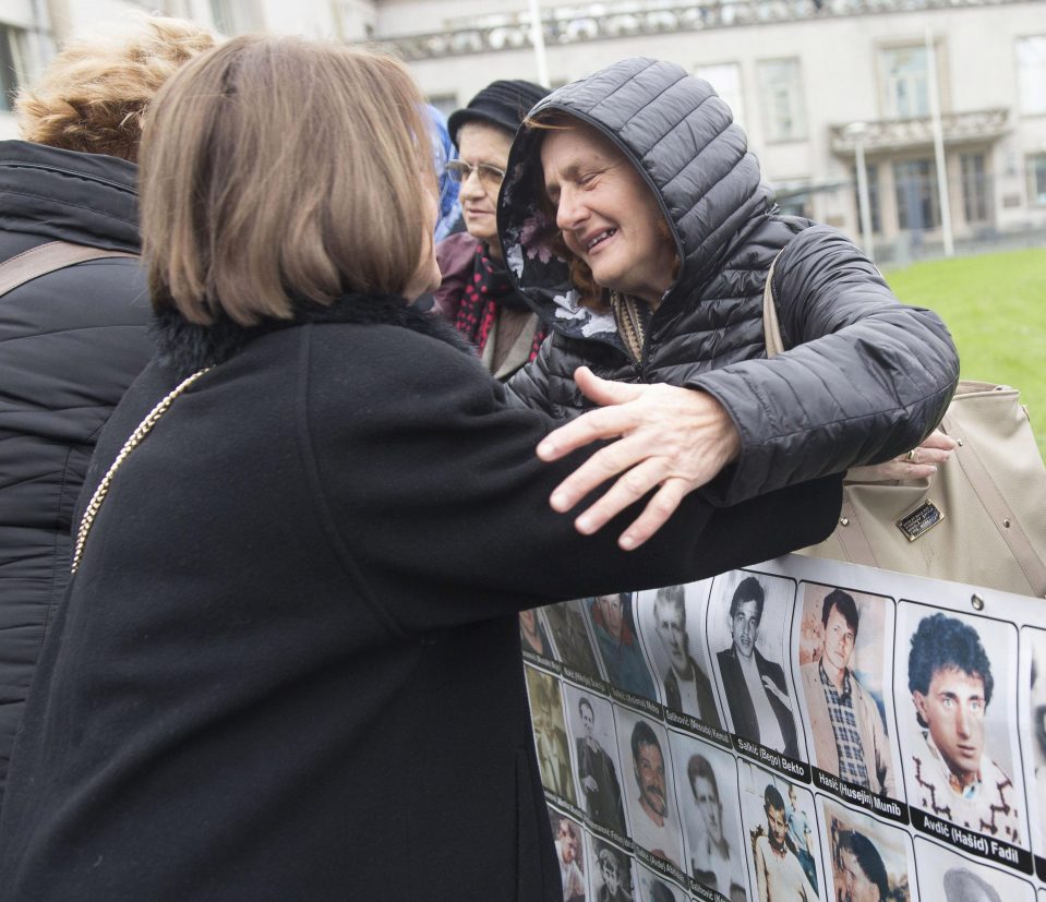  A relative of a victim is hugged outside the court ahead of the verdict