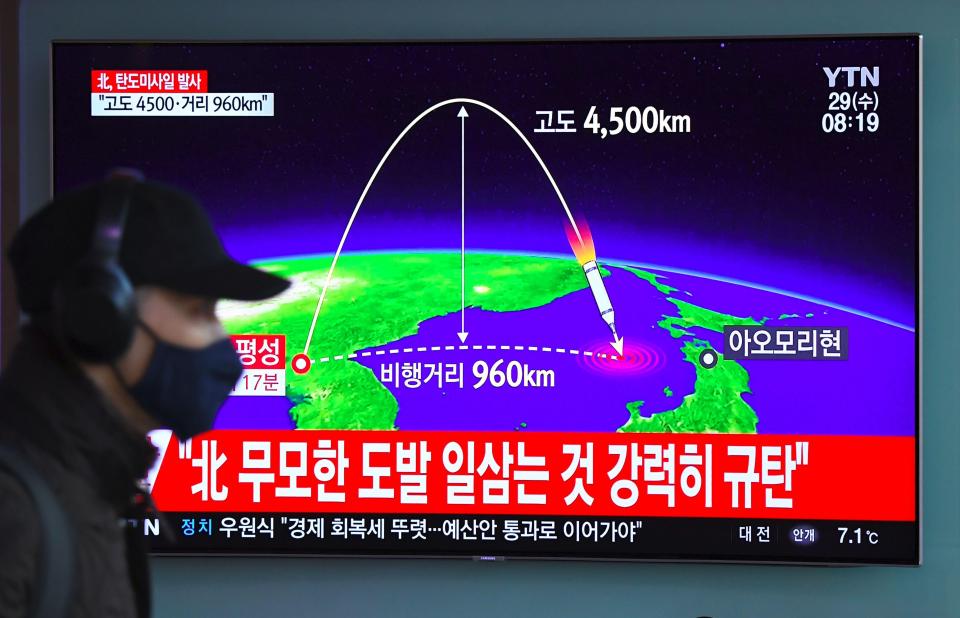 A man walks past a TV showing a graphic of the launch at a Seoul railway station 
