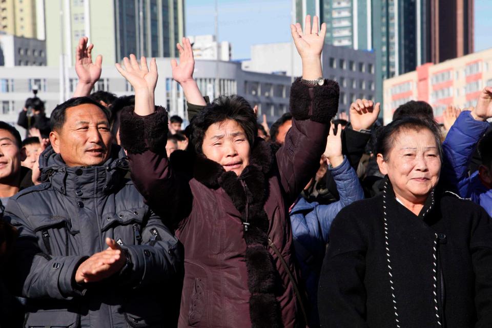  Locals cheers at Pyongyang Train Station as they hear the news