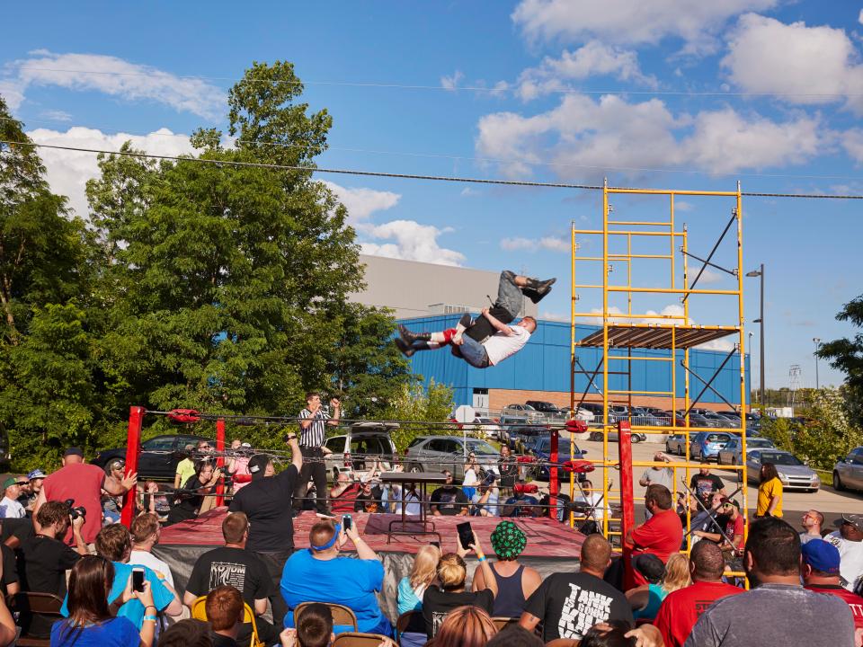  Wrestlers Devon Moore and John Wayne Murdoch flip off of scaffolding on to a table in the ring