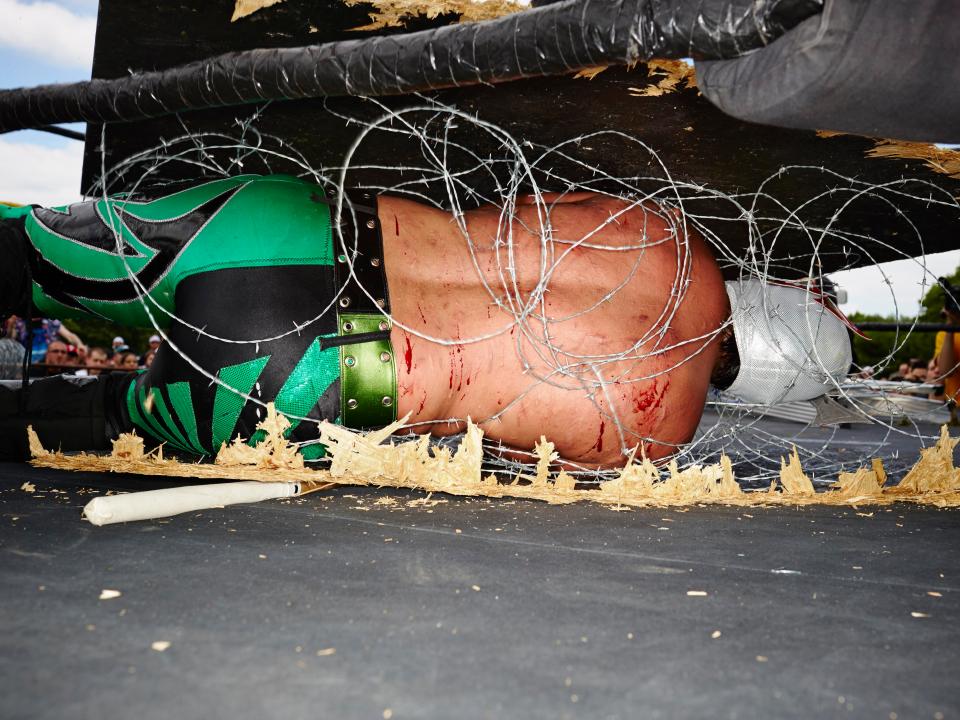  A wrestler lies in a painful bed of barbed wire