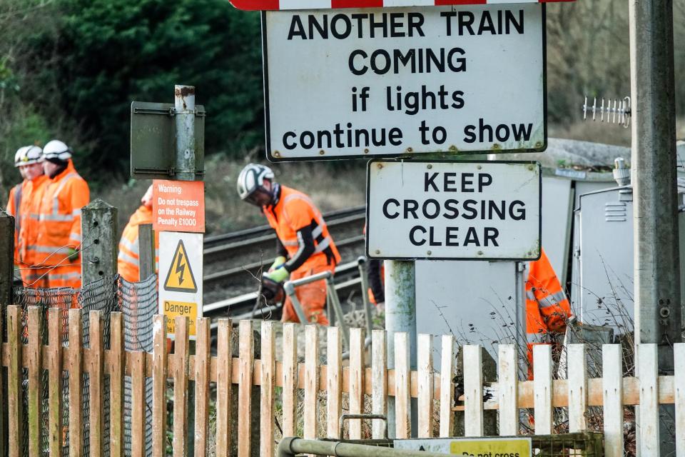 Workers clear a fallen tree from railway lines in Godalming