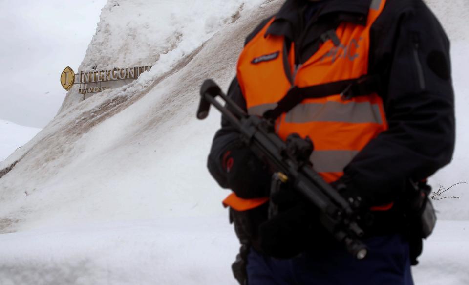 A Swiss police officer guards in front of a logo of the hotel InterContinental, where Trump stays during his visit 