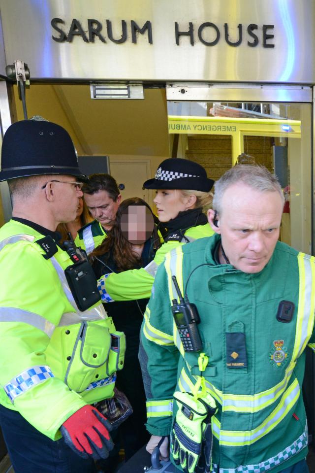 A woman led out from offices near Zizzi's by cops and paramedics where Skripal and Yulia dined