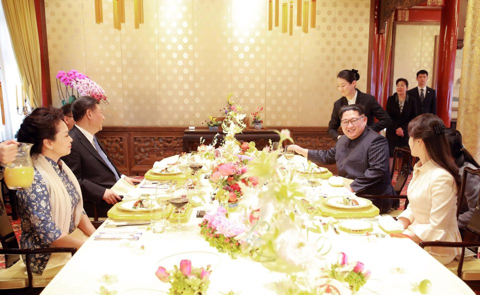  North Korean leader Kim Jong Un and wife Ri Sol Ju, and Chinese President Xi Jinping and wife Peng Liyuan eat at a beautifully decorated table
