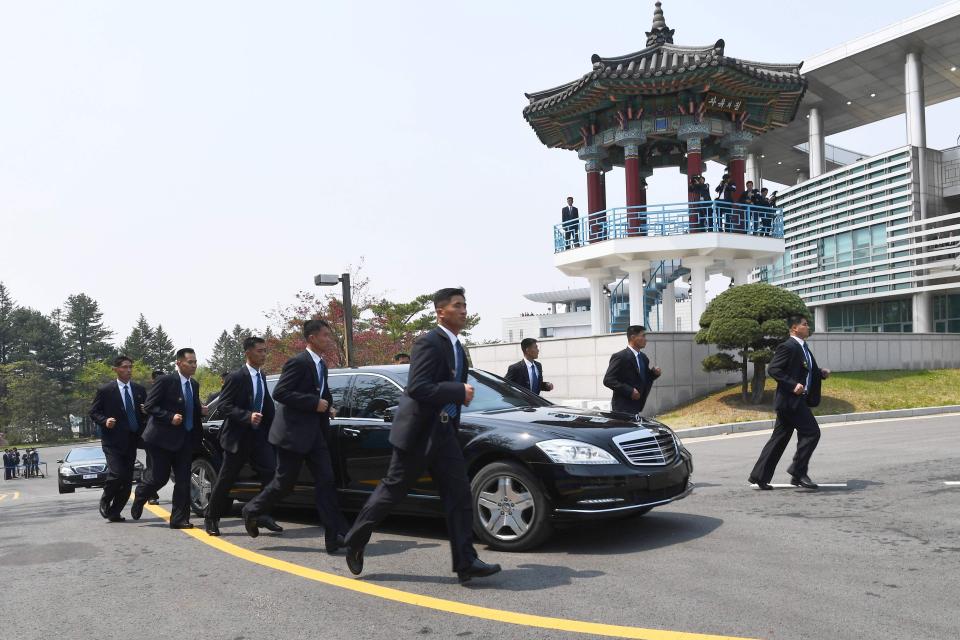 Suited guards mimicked the limo's every move