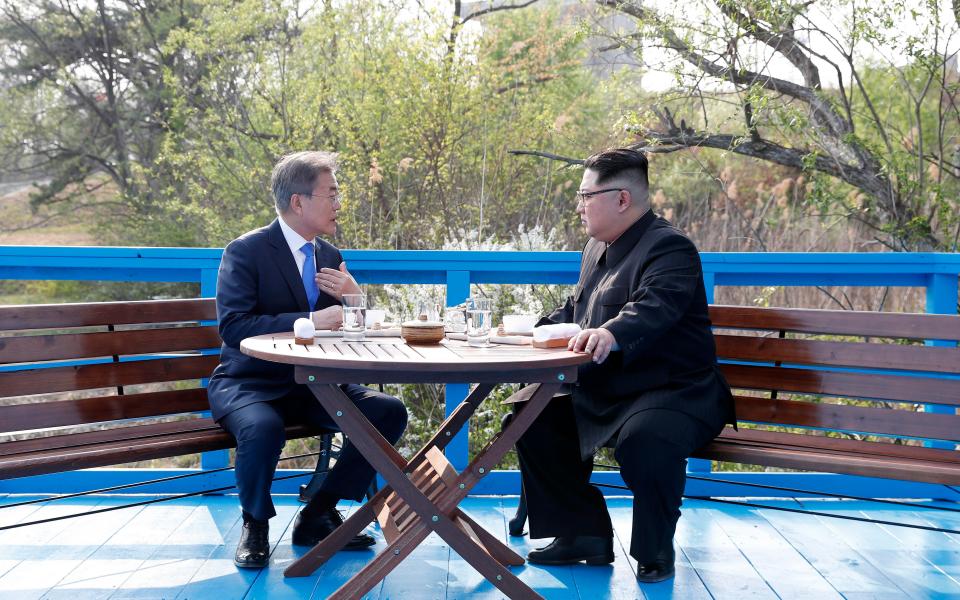 Moon and Kim sat at a table ahead of their historic statement where they appeared to be in high spirits