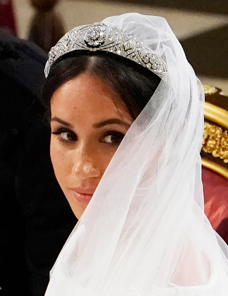 Meghan peers over her veil during the romantic ceremony