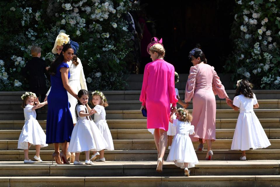 The bridesmaids and pageboys walk into the chapel, with the girls wearing matching white dresses