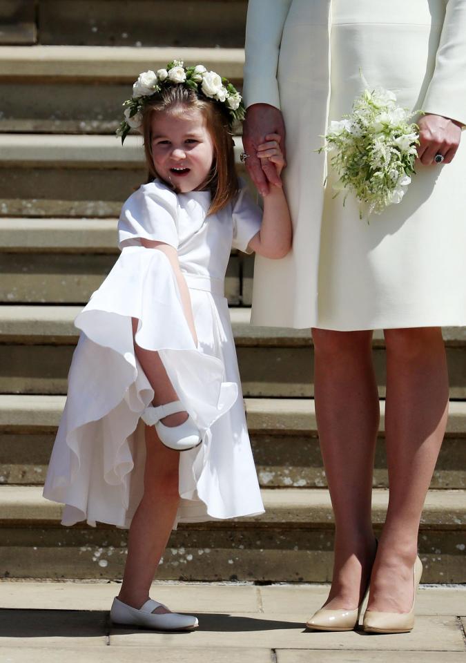 Princess Charlotte cheekily lifts up her legs as crowds gathered after the ceremony