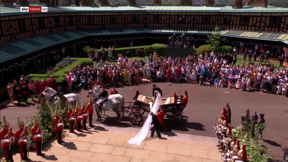 The bride's veil trails behind her as she and her new husband climb into the carriage after being declared husband and wife