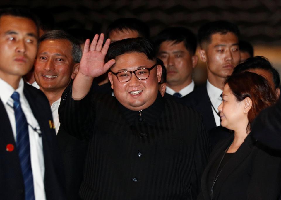 Kim waves to the cameras as he heads out for a stroll this evening