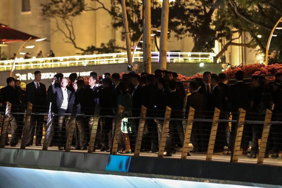 The bodyguards surround Kim as he takes a selfie with Singapore's Foreign Minister Vivian Balakrishnan and Education Minister Ong Ye Kung