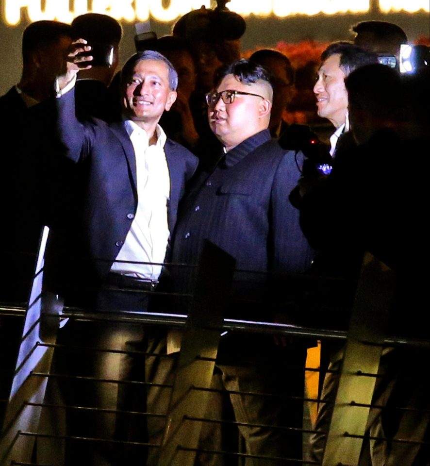 Kim grins as he poses for a selfie with the two local politicians
