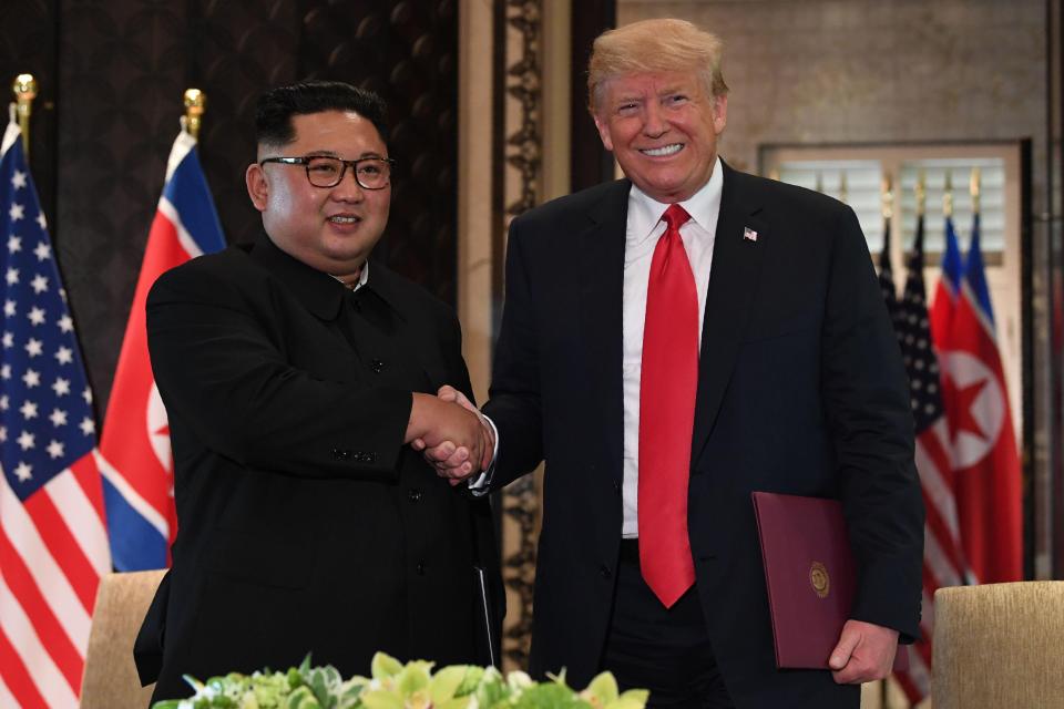  President Trump and Kim Jong-un shake hands following the signing ceremony