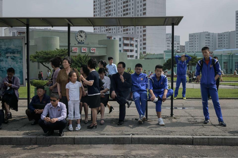  Commuters wait at a bus stop in Pyongyang on the day Donald Trump and Kim Jong Un became the first sitting US and North Korean leaders to meet, shake hands and negotiate to end a decades-old nuclear stand-off