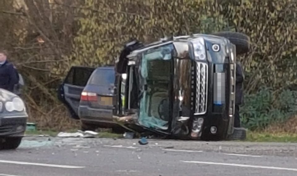 Prince Philip's flipped Land Rover next to Kia carrying two women and a baby