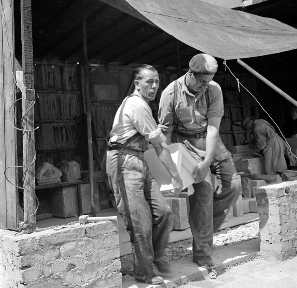  Churches were restored with the help of stone salvaged from the rubble of other churches. Here the salvaged stone is being carried by two workmen and will be loaded on to a lorry