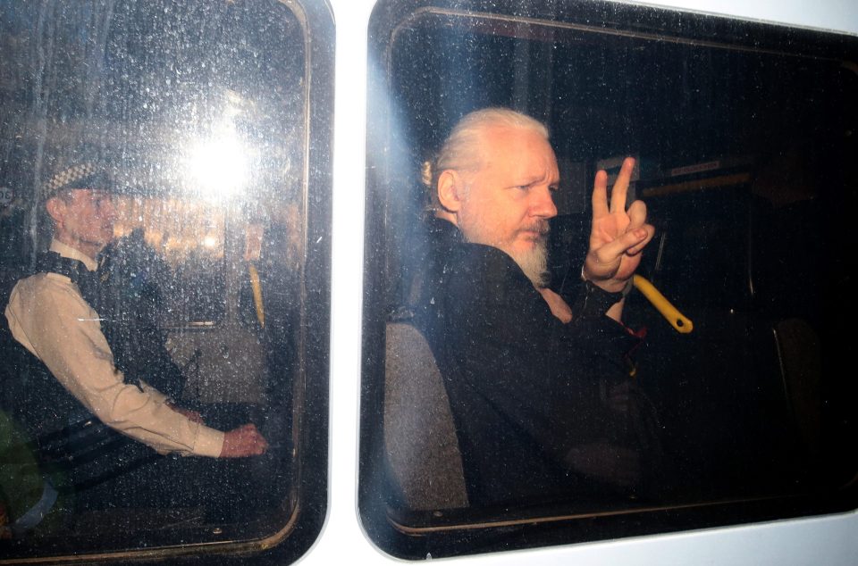  Assange flashed a peace sign in handcuffs