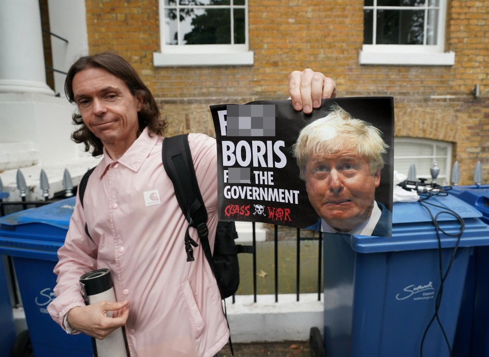 A protester posing with his anti-Boris Johnson poster outside his flat