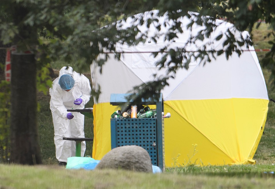 Police forensics examine a park bench in Monks Park Gardens in North West London, where the body of a man was discovered suffering gunshot to the head 