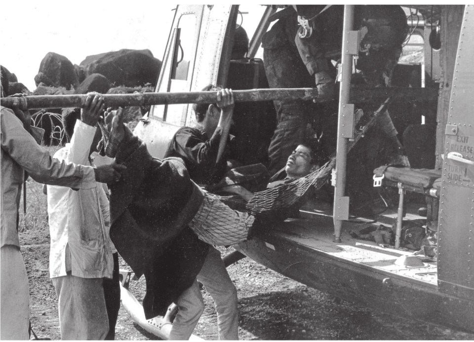  A shackled prisoner being loaded onto a chopper and hauled off